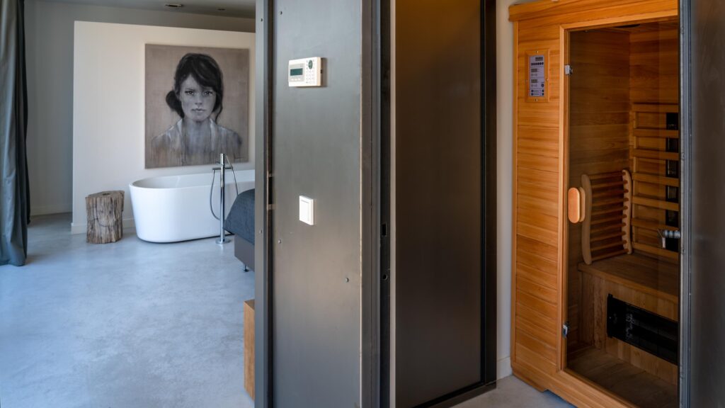 Interieurfoto van sauna en doorkijk naar badkamer in stalen boshuis